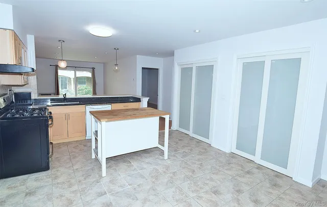 a kitchen with stainless steel appliances granite countertop a stove a sink and a refrigerator