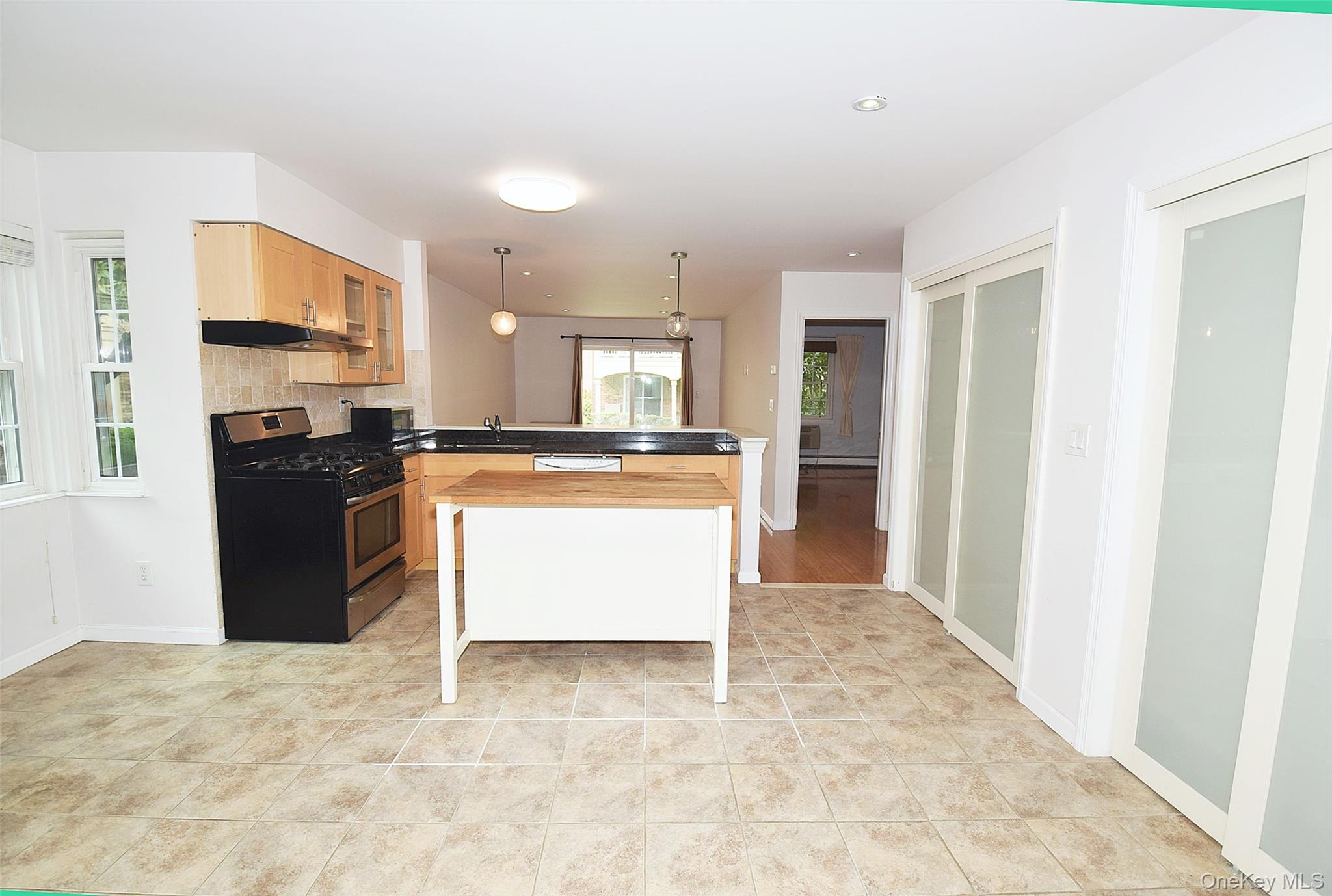 12-36 Estates Lane, Unit 49L Queens, NY 11360 - Photo 8 of 37 a large kitchen with stainless steel appliances granite countertop a stove a sink dishwasher and a refrigerator