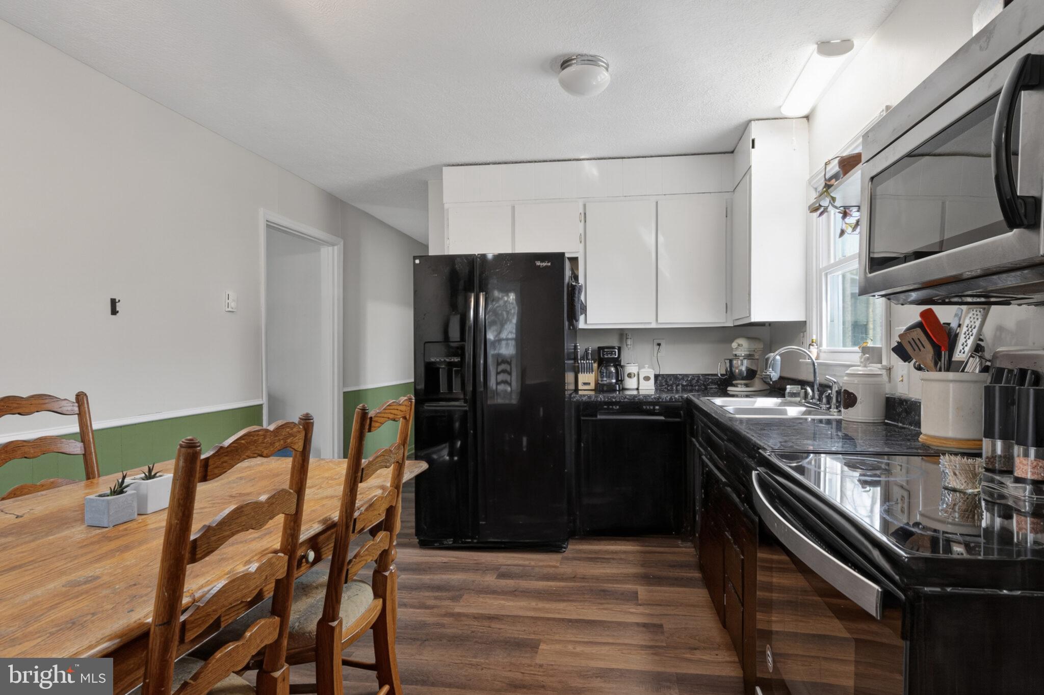 205 Monument Road Locust Grove, VA 22508 - Photo 12 of 49 a kitchen with stainless steel appliances granite countertop a refrigerator a stove a sink dishwasher with a dining table and chairs