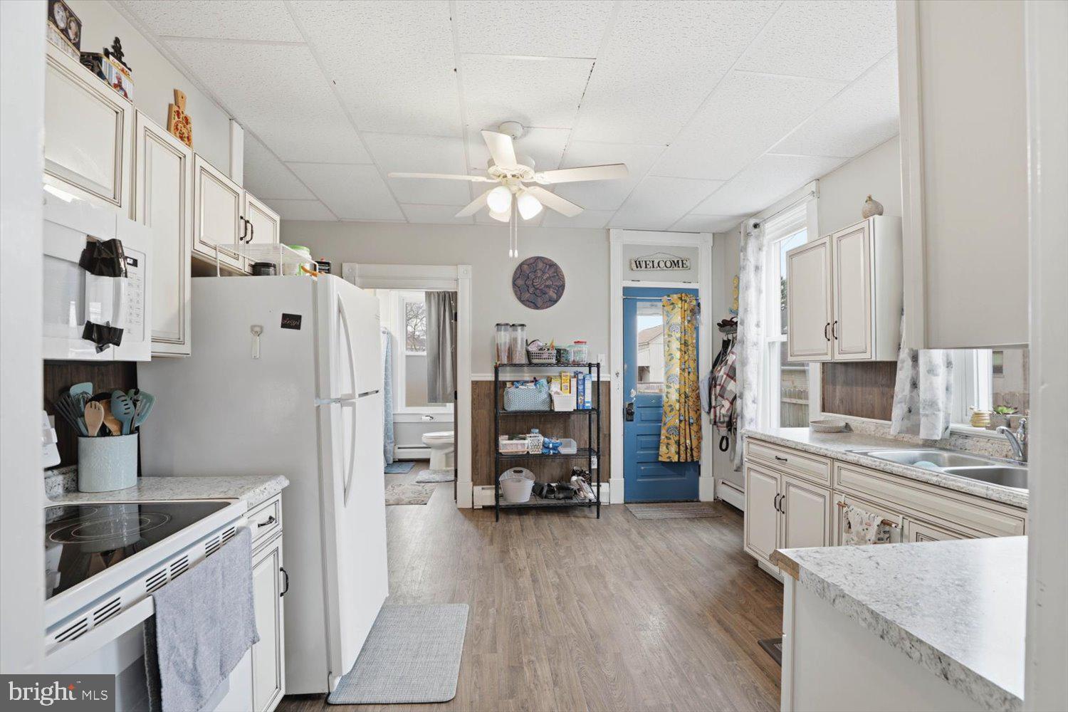 133 West High Street Manheim, PA 17545 - Photo 12 of 36 a kitchen with stainless steel appliances granite countertop a refrigerator a stove a sink and white cabinets with wooden floor