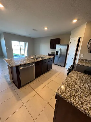 a kitchen with stainless steel appliances granite countertop a sink and a stove