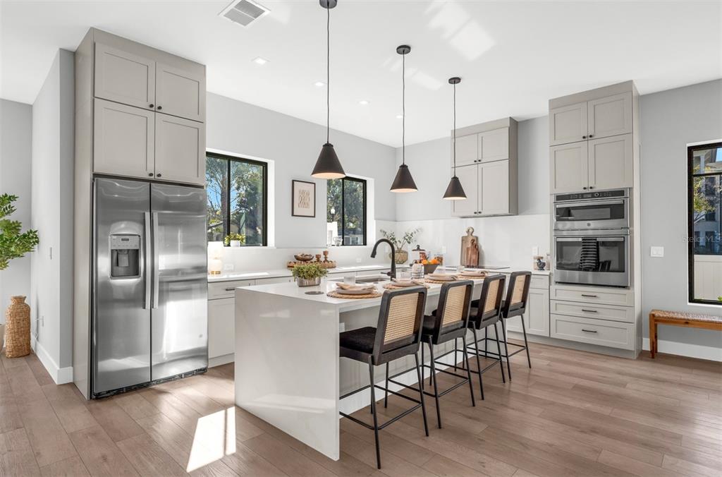 529 West Princeton Street Orlando, FL 32804 - Photo 15 of 50 a kitchen with stainless steel appliances kitchen island granite countertop a refrigerator a stove a sink a dining table and chairs with wooden floor