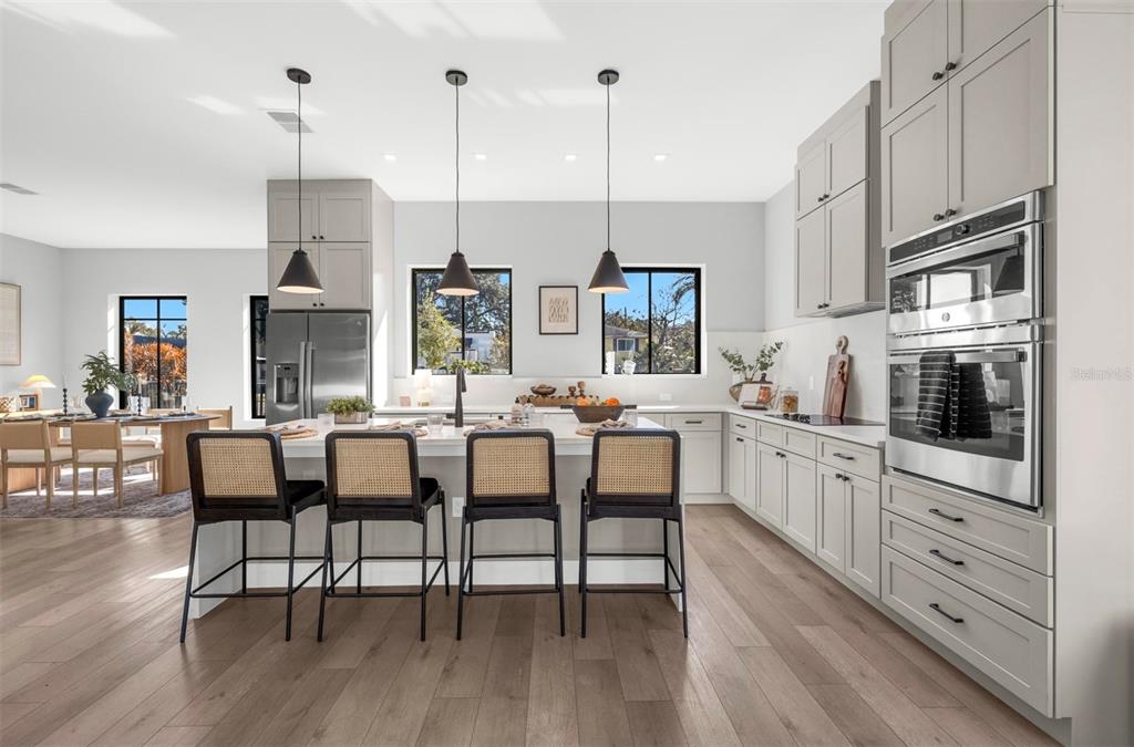 529 West Princeton Street Orlando, FL 32804 - Photo 16 of 50 a kitchen with stainless steel appliances kitchen island granite countertop a table chairs sink and cabinets