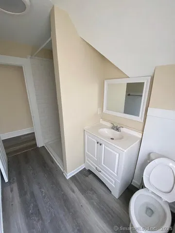 a bathroom with a toilet a sink a tub and mirror