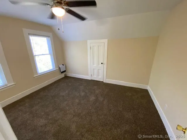 en empty room with windows and fan