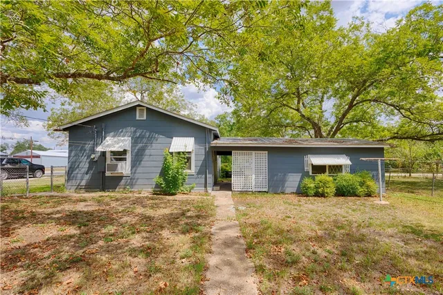 a house that has a tree in front of it