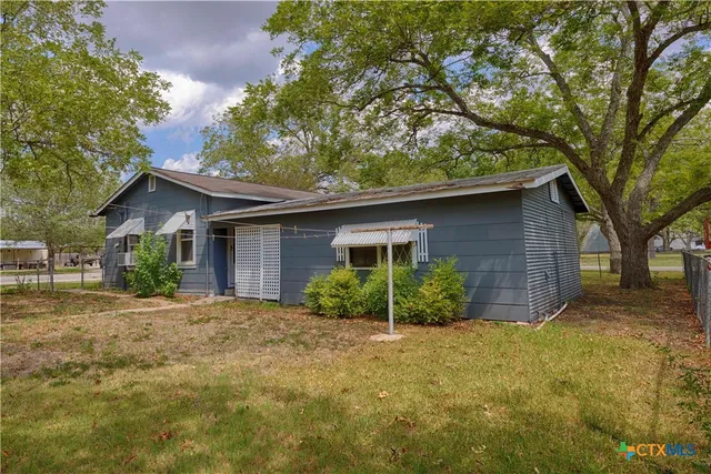 a front view of house with yard and trees