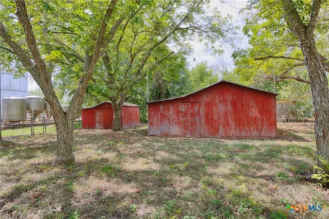 a house is sitting in middle of the forest