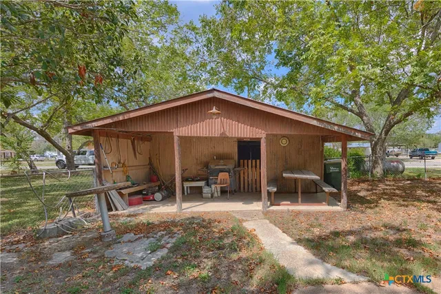 a backyard of a house with table and chairs