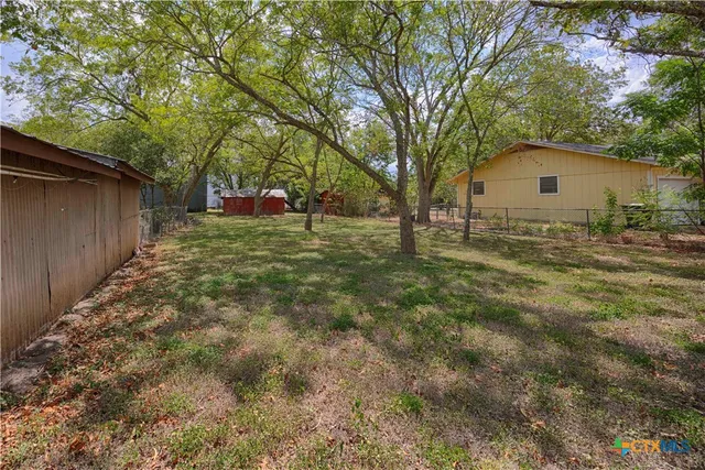 a backyard of a house with table and chairs