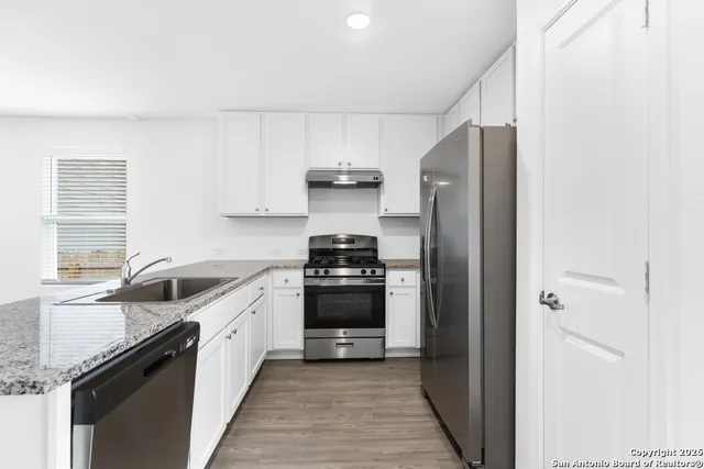 a kitchen with stainless steel appliances granite countertop a stove and a refrigerator