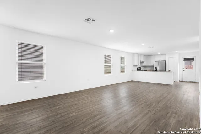 a view of a kitchen with wooden floor and windows