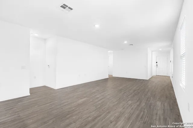 a view of an empty room with wooden floor