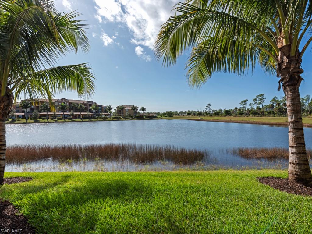9723 Acqua Court, Unit 332 Naples, FL 34113 - Photo 12 of 23 a view of a lake with a big yard and palm trees