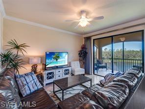 9723 Acqua Court, Unit 332 Naples, FL 34113 - Photo 2 of 23 a living room with furniture a flat screen tv and a large window