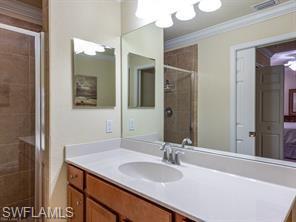 9723 Acqua Court, Unit 332 Naples, FL 34113 - Photo 9 of 23 a bathroom with a sink and a mirror