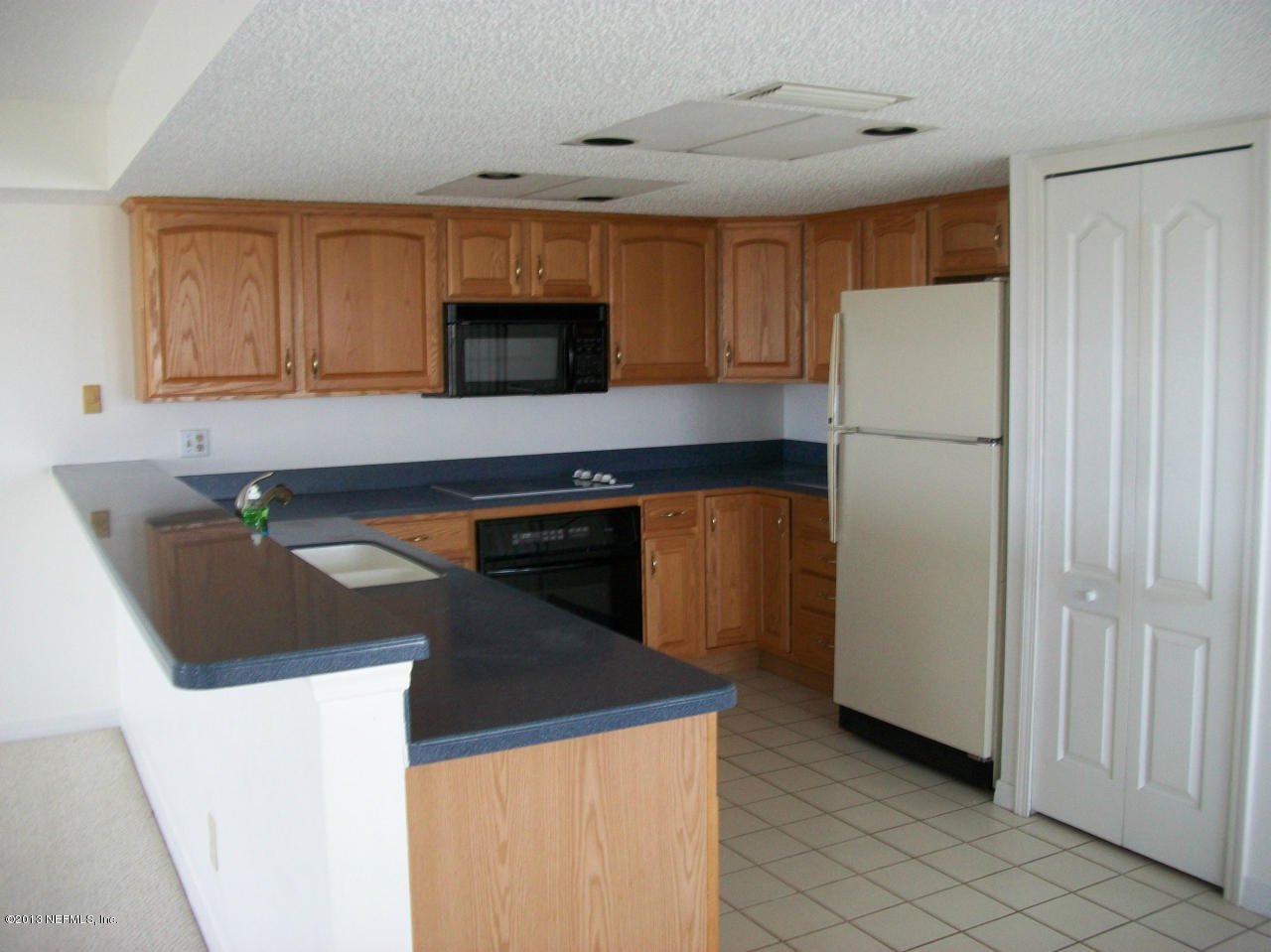 3387 Lighthouse Point Lane Jacksonville, FL 32250 - Photo 8 of 8 a kitchen with a sink a stove and refrigerator