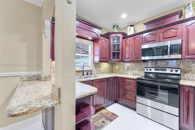 a kitchen with stainless steel appliances granite countertop a stove and a microwave