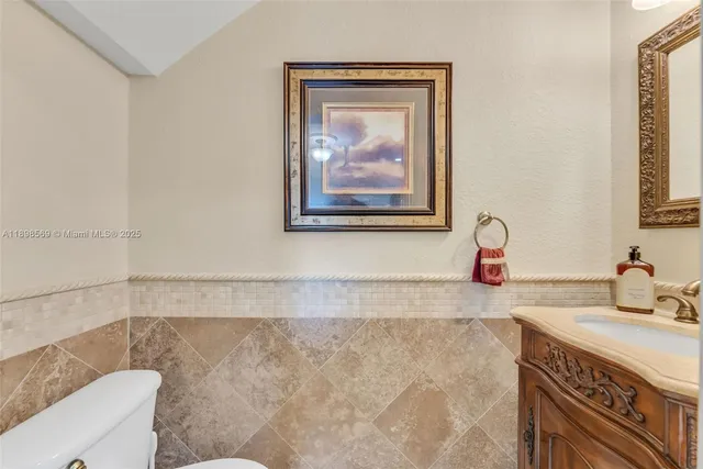 a bathroom with a granite countertop sink a mirror and a bathtub