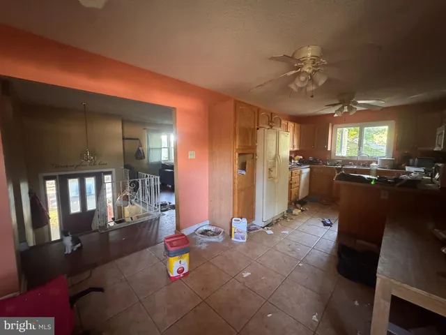 a kitchen with stainless steel appliances granite countertop a refrigerator a sink dishwasher a dining table and chairs with wooden floor