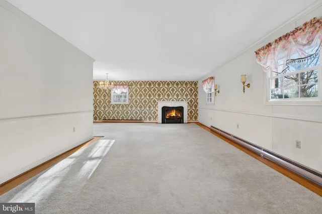 a view of an empty room with a fireplace and a window