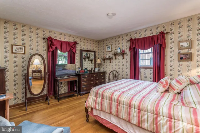 a bedroom with a bed and dresser with mirror