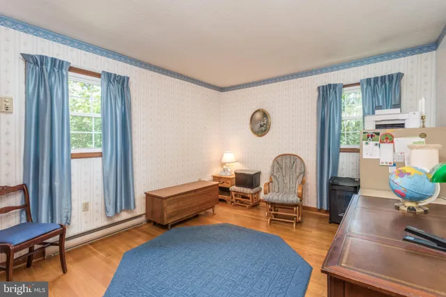 a living room with furniture a window and wooden floor