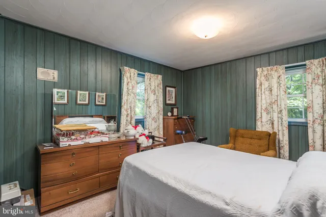 a bedroom with a bed and large windows