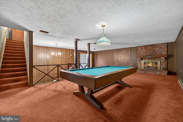 a view of an empty room with windows & lounge chair