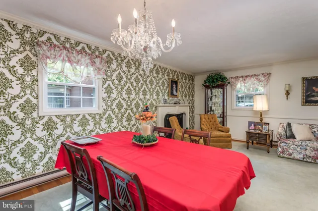 a bedroom with a bed a chandelier and a dresser
