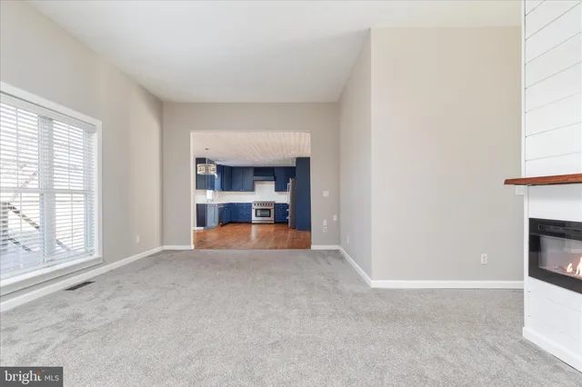 a view of empty room with a fireplace and window