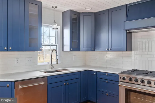 a kitchen with stainless steel appliances granite countertop a sink a stove and cabinets