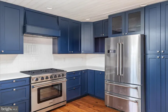 a kitchen with a refrigerator stove and wooden cabinets
