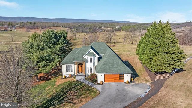 an aerial view of a house with a yard and lake view