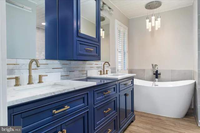 a white bath tub sitting in a bathroom next to a window