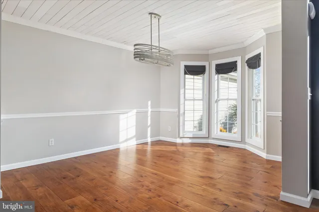 a view of a hallway with wooden floor and entryway
