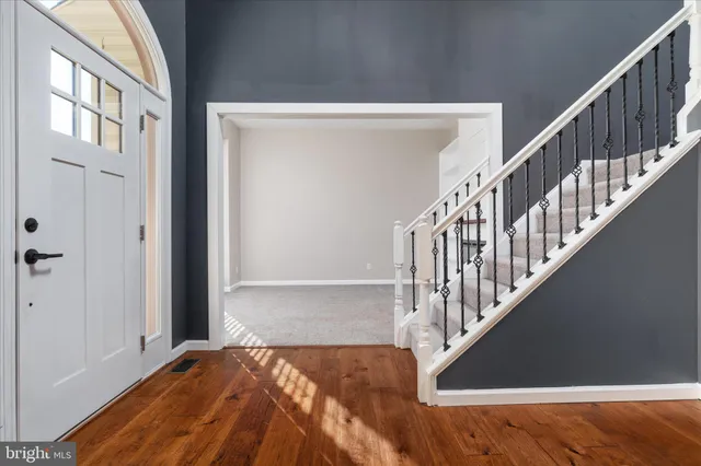 a view of a hallway with wooden floor and entryway