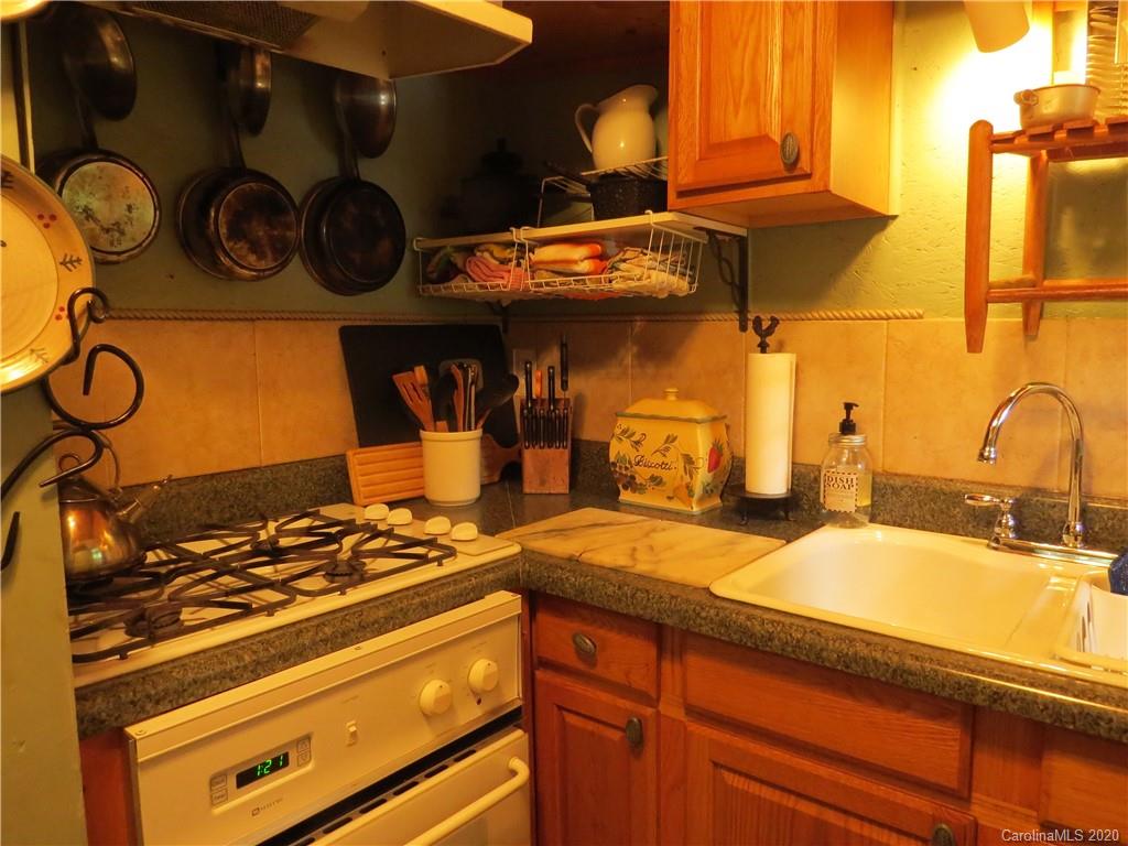 142 Cold Spring Road Burnsville, NC 28714 - Photo 17 of 34 a kitchen with a stove and cabinets