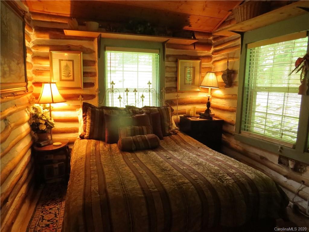 142 Cold Spring Road Burnsville, NC 28714 - Photo 21 of 34 a bedroom with a bed and wooden floor