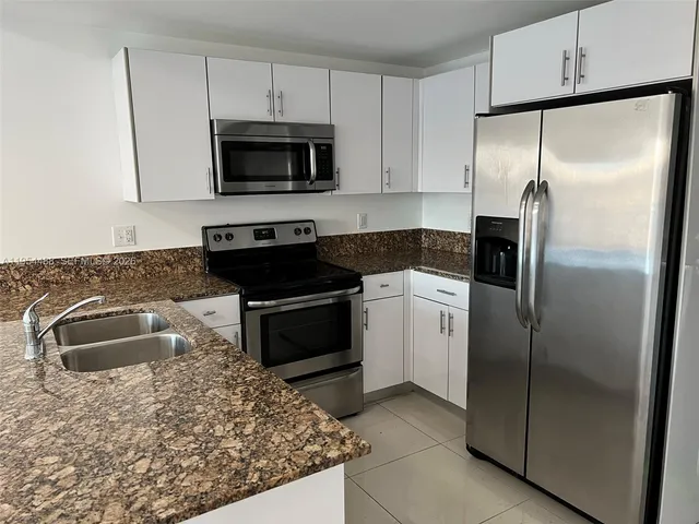 a kitchen with a refrigerator sink and stove
