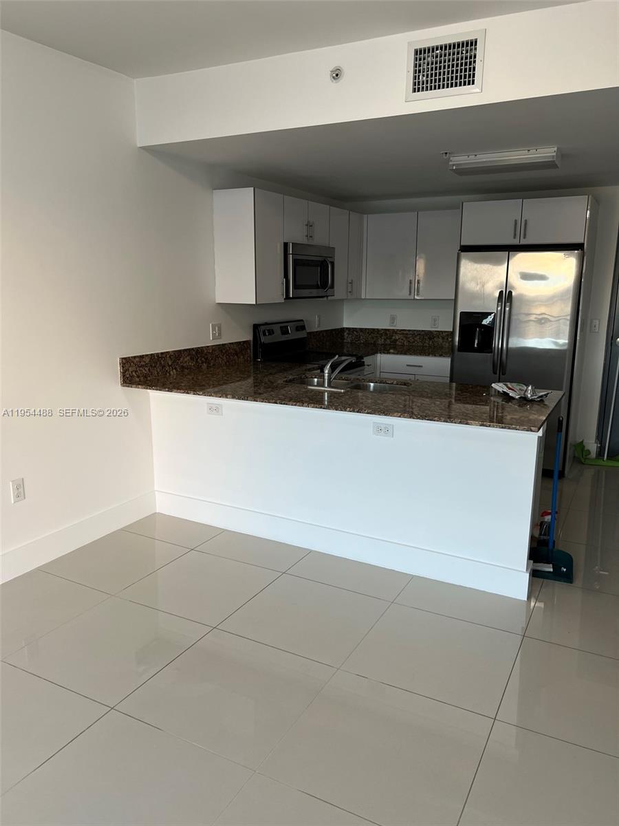 2300 Northwest 7th Street, Unit 308 Miami, FL 33125 - Photo 7 of 15 a kitchen with stainless steel appliances a sink a stove top oven a counter space and cabinets