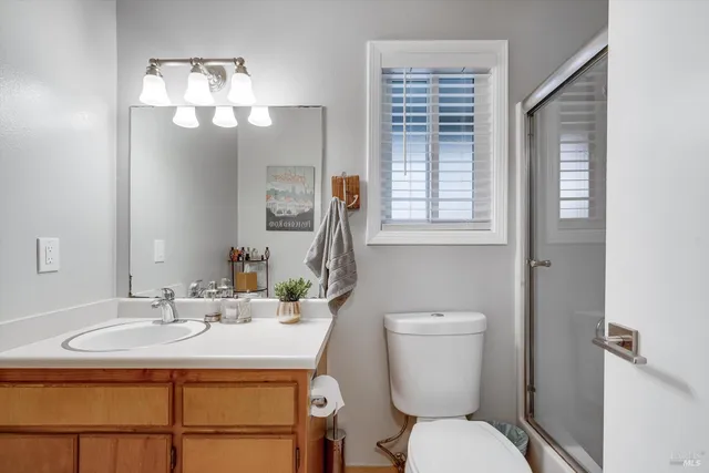 a bathroom with a toilet a sink and mirror