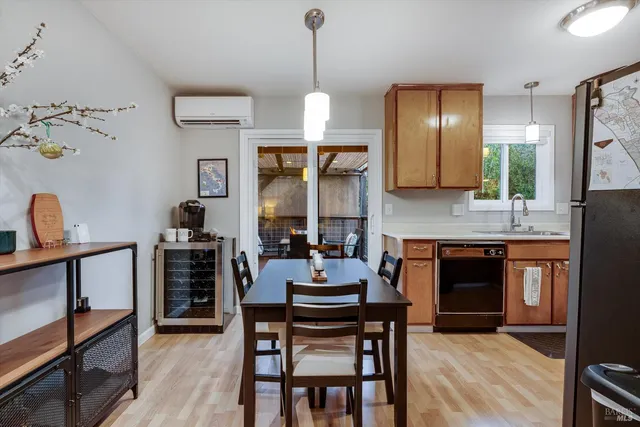 a kitchen with a dining table chairs cabinets and stainless steel appliances