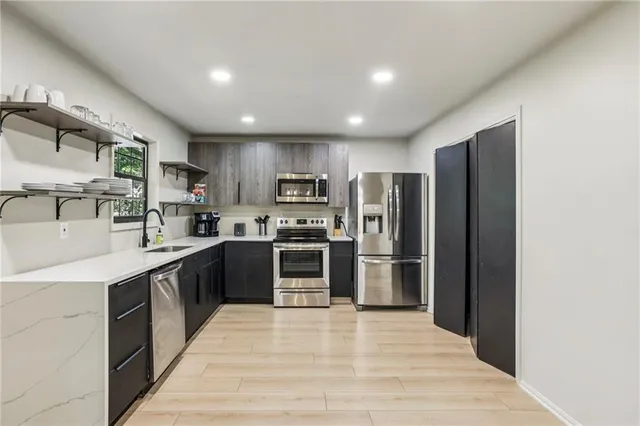 a kitchen with stainless steel appliances granite countertop a refrigerator and a stove top oven