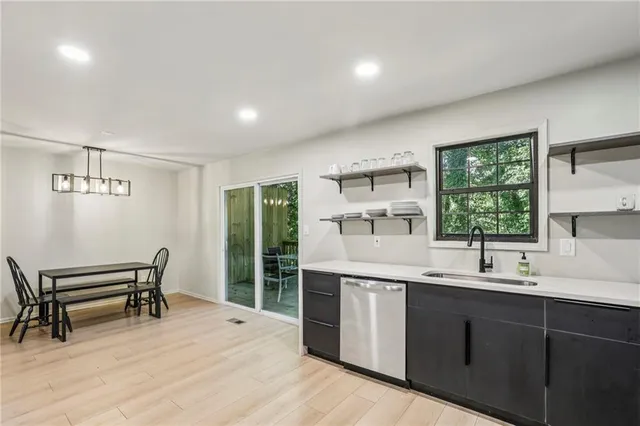 a kitchen with a sink a window and chairs