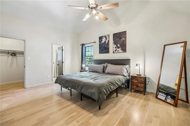 a spacious bedroom with a bed and a flat screen tv