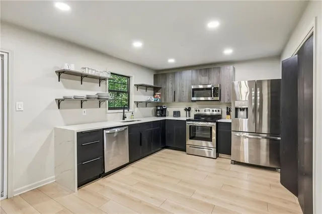 a kitchen with granite countertop a refrigerator and a stove top oven