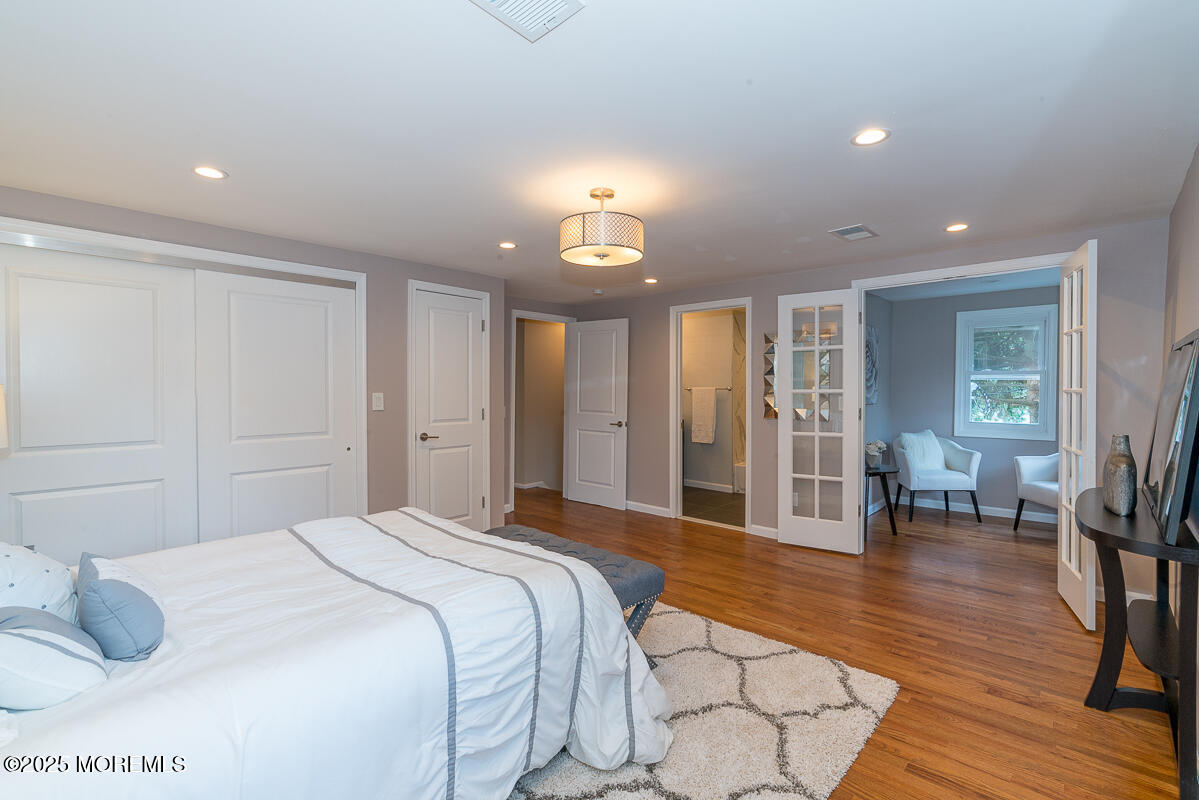 21 Wickatunk Road Manalapan, NJ 07726 - Photo 15 of 48 a spacious bedroom with a bed a table and wooden floor