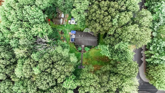 an aerial view of a house with a yard and outdoor seating
