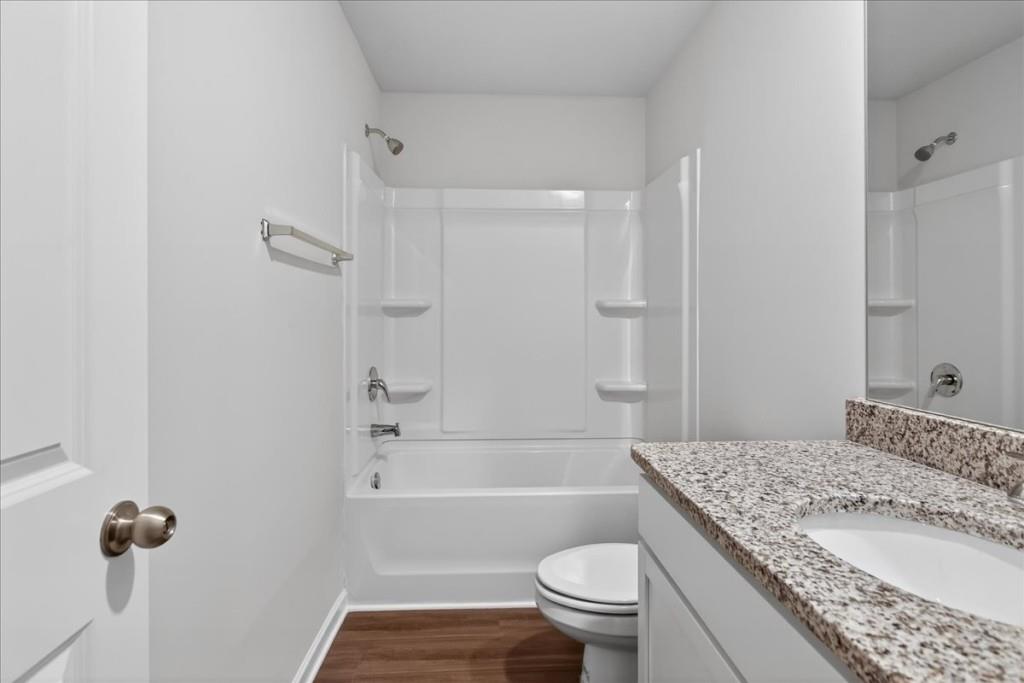 107 Brexley Drive Calhoun, GA 30701 - Photo 32 of 36 a bathroom with a granite countertop bathtub sink vanity mirror and toilet